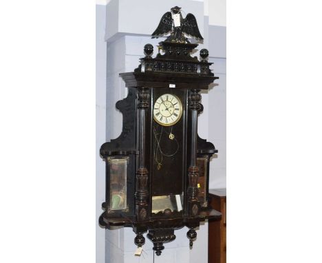 A Vienna style ebonised wall clock, circa 1900, with enamelled roman dial, subsidiary seconds dial, the case with ornate eagl