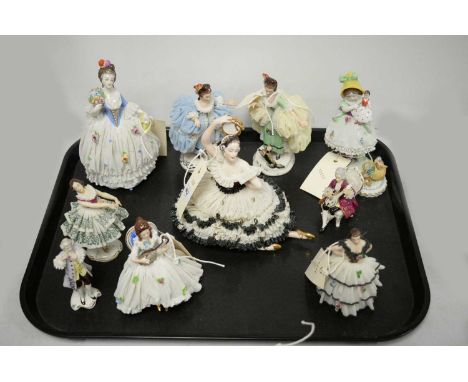 A selection of Dresden and other Continental ceramic crinoline figures, each in lacework style dress, some modelled playing m