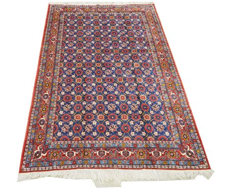 A Varamin carpet, with flowerhead decoration on blue ground, 330 x 213cms.