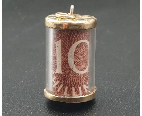 A VINTAGE 9K GOLD CHARM/PENDANT WITH A TEN SHILLING NOTE FOLDED INSIDE A CONTAINER.3.3gms    2cms 