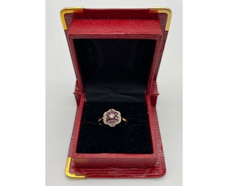 A VINTAGE 18K GOLD RUBY AND DIAMOND CLUSTER RING. 4.5gms size O