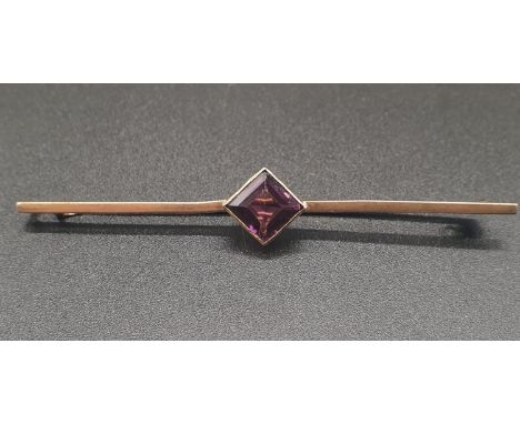 A VINTAGE 9K ROSE GOLD BAR BROOCH WITH CENTRAL SQUARE AMATHYST STONE.3.1gms   6cms 