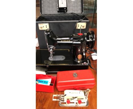 Singer 222K Featherweight sewing machine from the mid-20th century. Features classic black enamel finish, complete with origi