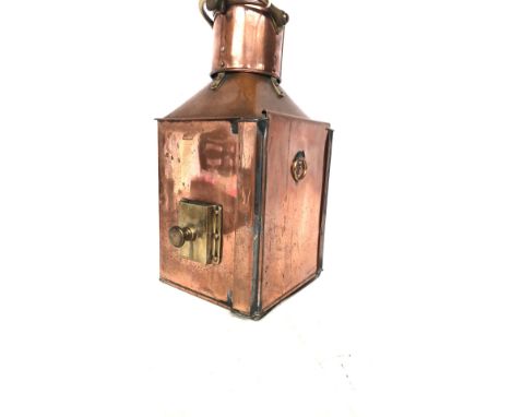 Antique copper and brass ship’s bow port lantern from the early 20th century. It includes a curved glass lens, riveted constr