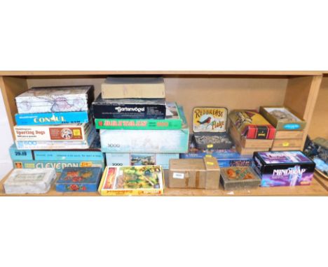 A quantity of boxed jigsaw puzzles, including The Masks in Guatemala, a hillside view and sporting dogs.