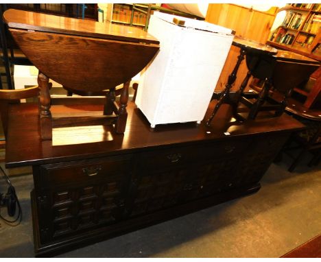 An oak sideboard, with three frieze drawers, four cupboard doors below, raised on a plinth base, two matching drop leaf occas