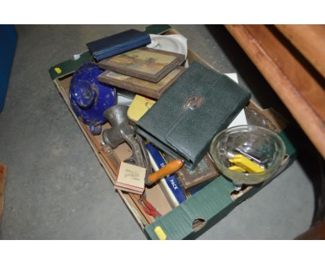 A box containing various sundry items to include an enamel chamber stick; various tins; lighters; a mincer; two small oil on 