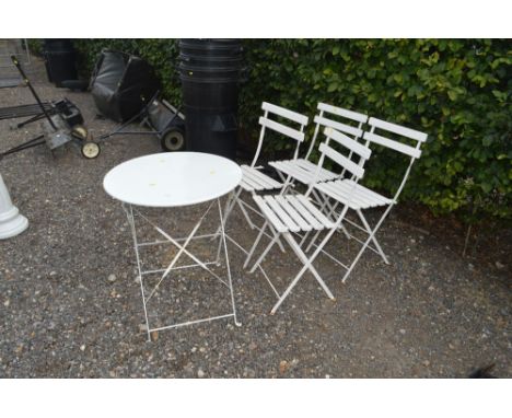 A bistro table and four white folding chairs 