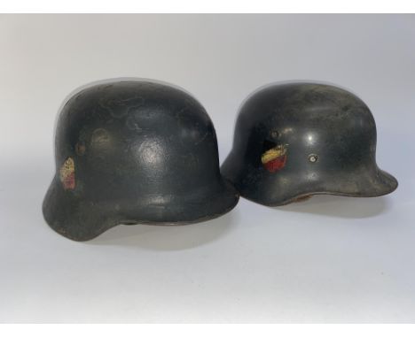 A second World War German steel combat helmet, with tri-colour shield decal and another