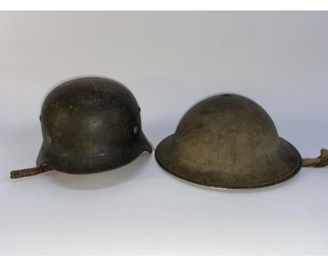 A second World War German steel helmet with leather chin strap and a Brodie helmet