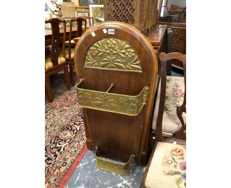 AN ARTS AND CRAFTS MAHOGANY AND BRASS STICK STAND WITH A ROUND ARCHED BACK TO THE FLORAL BRASS WORK