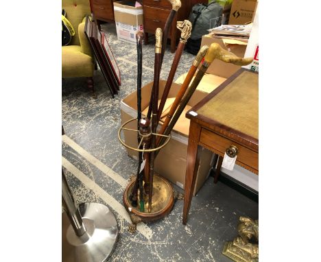 A BRASS AND MAHOGANY CIRCULAR STICK STAND TOGETHER WITH SIX WALKING STICKS