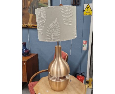A BRUSHED COPPER TABLE LAMP, THE PEAR SHAPE DIVIDED AT ITS GIRTH AND LIT WITHIN BY A SECOND LIGHT SOCKET