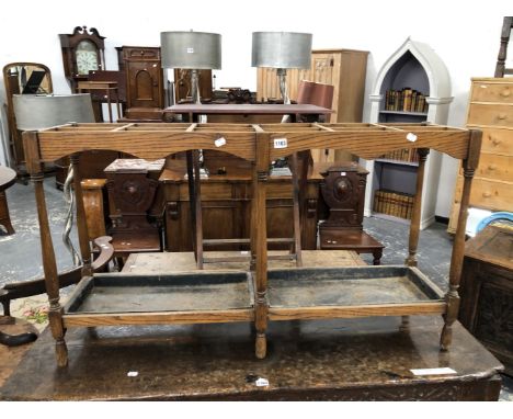 AN EARLY 20th C, OAK STICK STAND WITH TWELVE COMPARTMENTS ABOVE TWO IRON DROP IN TRAYS AND SPINDLE FEET