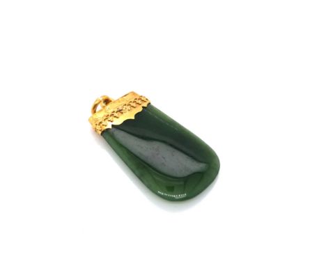 A VINTAGE JADE PENDANT WITH AN ORNATE PENDANT CAP. NO ASSAY MARKS, STAMPED 15, ASSESSED AS 18ct GOLD. LENGTH INCLUDING BAIL 4