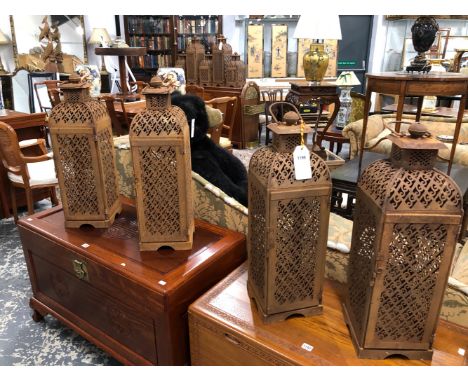 A SET OF FOUR PIERCED IRON PRICKET CANDLESTICK LANTERNS