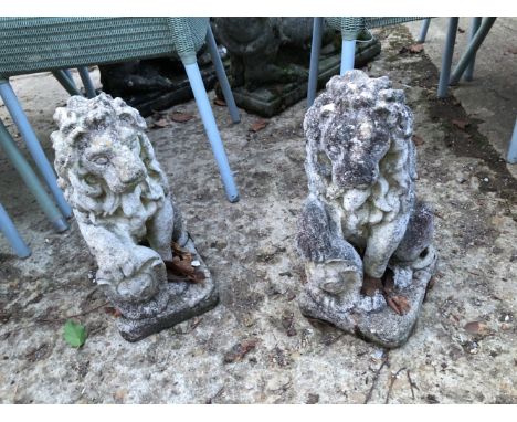 A PAIR OF RECONSTITUTED STONE SEATED LION GATE POST FINIALS.