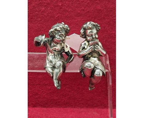 TWO VICTORIAN SILVER ELECTROPLATED PUTTO FURNITURE MOUNTS, THE SEATED FIGURES PLAYING CYMBALS AND PAN PIPES, KITE SHAPED REGI