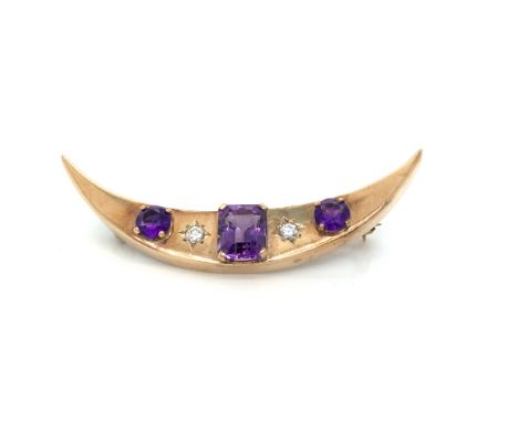 A VINTAGE DIAMOND AND AMETHYST CRESCENT MOON BROOCH. THE CENTRAL AMETHYST AN EMERALD CUT, MEASUREMENTS 8.4 X 6.8 X D 5.4mm. C