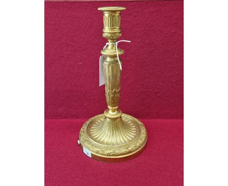 AN ORMOLU CANDLESTICK TABLE LAMP, THE FLUTED COLUMN WITH FOLIAGE BANDS. THE CIRCULAR FOOT WITH A LAUREL LEAF BAND.   H 30cms.