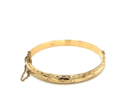 A VINTAGE 9ct HALLMARKED GOLD HINGED BANGLE COMPLETE WITH ATTACHED SAFETY CHAIN. DATED 1994, BIRMINGHAM WITH PAT NO. WEIGHT 8