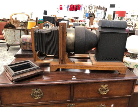 AN OAK AND BLACKENED METAL MAGIC LANTERN LIT BY OIL OR CANDLE LIGHT