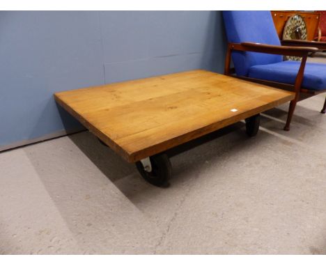 A TERENCE CONRAN ROLLER COFFEE TABLE, OAK RECTANGULAR PLATFORM ON FOUR RUBBER WHEELS, THE TOP. 120 x 81cms