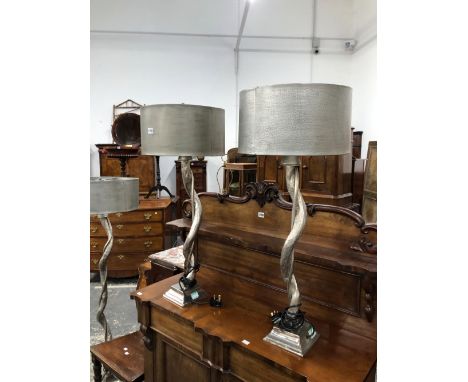 A PAIR OF ALUMINIUM SINUOUS TREE TRUNK TABLE LAMPS WITH METAL SHADES TOGETHER WITH A SIMILAR STANDARD LAMP