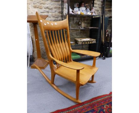 TWO BLOND WOOD ROCKING CHAIRS, ONE WITH A RUSH SEAT AND STICK BACK AND THE OTHER WITH A SADDLE SEAT AND SEVEN STRAP BACK AFTE