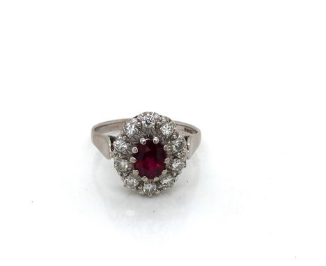 AN 18ct WHITE GOLD HALLMARKED AND HIGH QUALITY RUBY AND DIAMOND CLUSTER RING. THE OVAL CLAW SET RUBY IN A 10 CLAW SETTING. TH