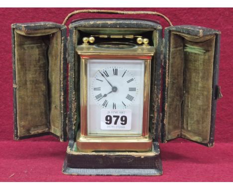 A LEATHER CASED CARRIAGE TIMEPIECE WITH A WHITE ENAMEL DIAL, THE CASE.   H 15.5cms.