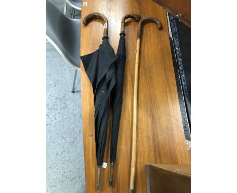 TWO BLACK UMBRELLAS, TWO WALKING CANES AND A LEATHER HANDLED BAMBOO WALKING STICK