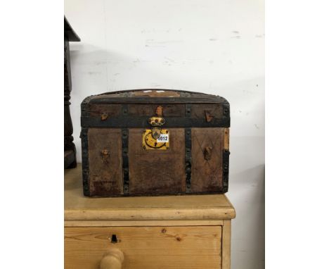 AN IRON STRAP BOUND LEATHER COVER TRUNK WITH A ROUND ARCH LID.   W 40cms.