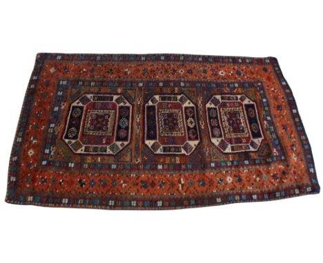 A Chajli pattern rug, the three geometric medallions enclosed by blue openwork spandrels and recurrent borders, 196cm x 110cm