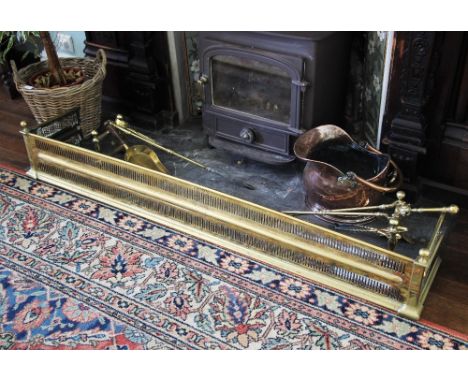 * A 19th century pierced brass fender, straight front with spherical finials, 162cm wide, a copper coal helmet with swing han