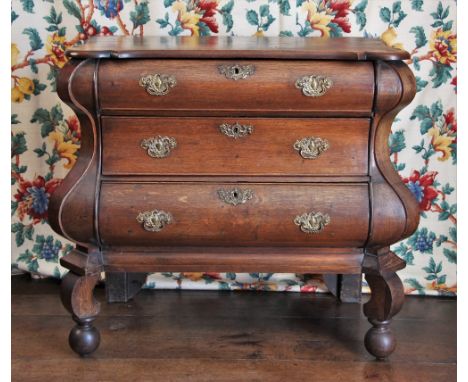 * A Dutch oak commode/chest of drawers, 18th century, of bombe form, the shaped and rounded top of baroque form over a serpen