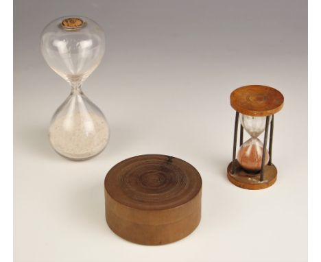 A 19th century glass sand timer, of typical form, with cork stopper, 12cm high, a second smaller example within a rod and tre