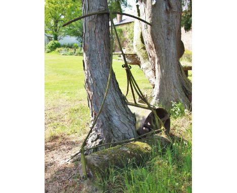 * A sandstone and wrought iron garden roller, 87cm W 