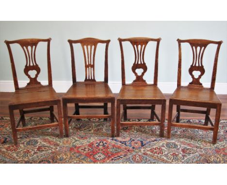 * A matched set of four George III oak and elm country Chippendale style dining chairs, each with a pierced vase shaped splat