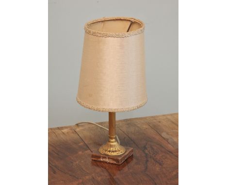 * A gilt metal column table lamp, the fluted column extending to a leaf moulded base upon a square marble plinth, complete wi