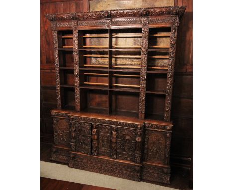 * A 17th style carved oak Flemish bookcase, 19th century, the cornice carved with scrolling foliate detail punctuated by reli