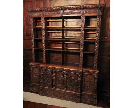 * A 17th style carved oak Flemish bookcase, 19th century, the cornice carved with scrolling foliate detail punctuated by reli