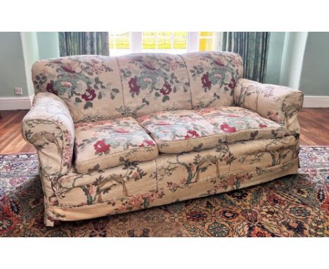 * A late 19th century three seater sofa, in the manner of Howard & Sons, the undulating back rest extending to padded scrolle