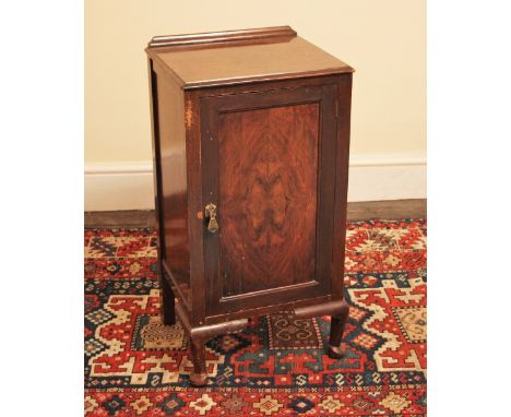 * An early 20th century walnut bedside cupboard, with a single figured cupboard door, upon short cabriole legs, 76cm high, al