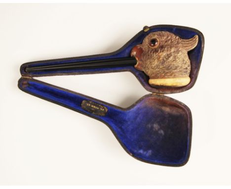 A carved meerschaum pipe, 19th century, the pipe mounted with a carved head of a exotic bird with inset glass eyes, 17cm long