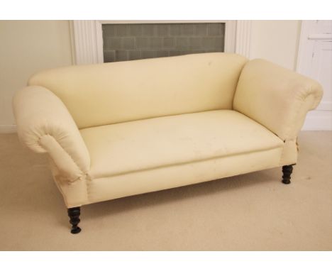 * A Victorian drop-end Chesterfield type sofa, of deep set form with scrolled padded back and arms, upon vase shaped front le