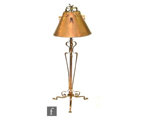 In the manner of George Walton - A copper standard lamp, with a stylised whiplash base beneath the studded conical copper sha