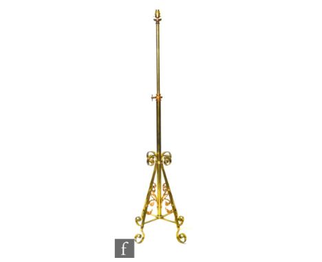 Unknown - A brass standard lamp of adjustable height, raised to four scrollwork feet with acanthus leaf detail united by a cr