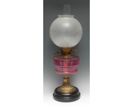 An early 20th century cranberry glass and brass table oil lamp, globular etched glass shade, Duplex-type adjustable double bu