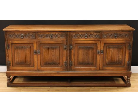 An Old Charm oak low dresser, rectangular top above four frieze drawers and two pairs of linenfold panel doors, each pair enc